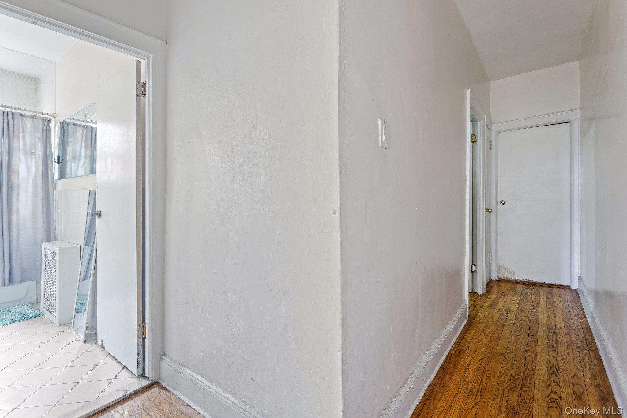 34-29 58th Street Queens, NY 11377 - Photo 7 of 23 a view of a hallway with wooden floor and staircase