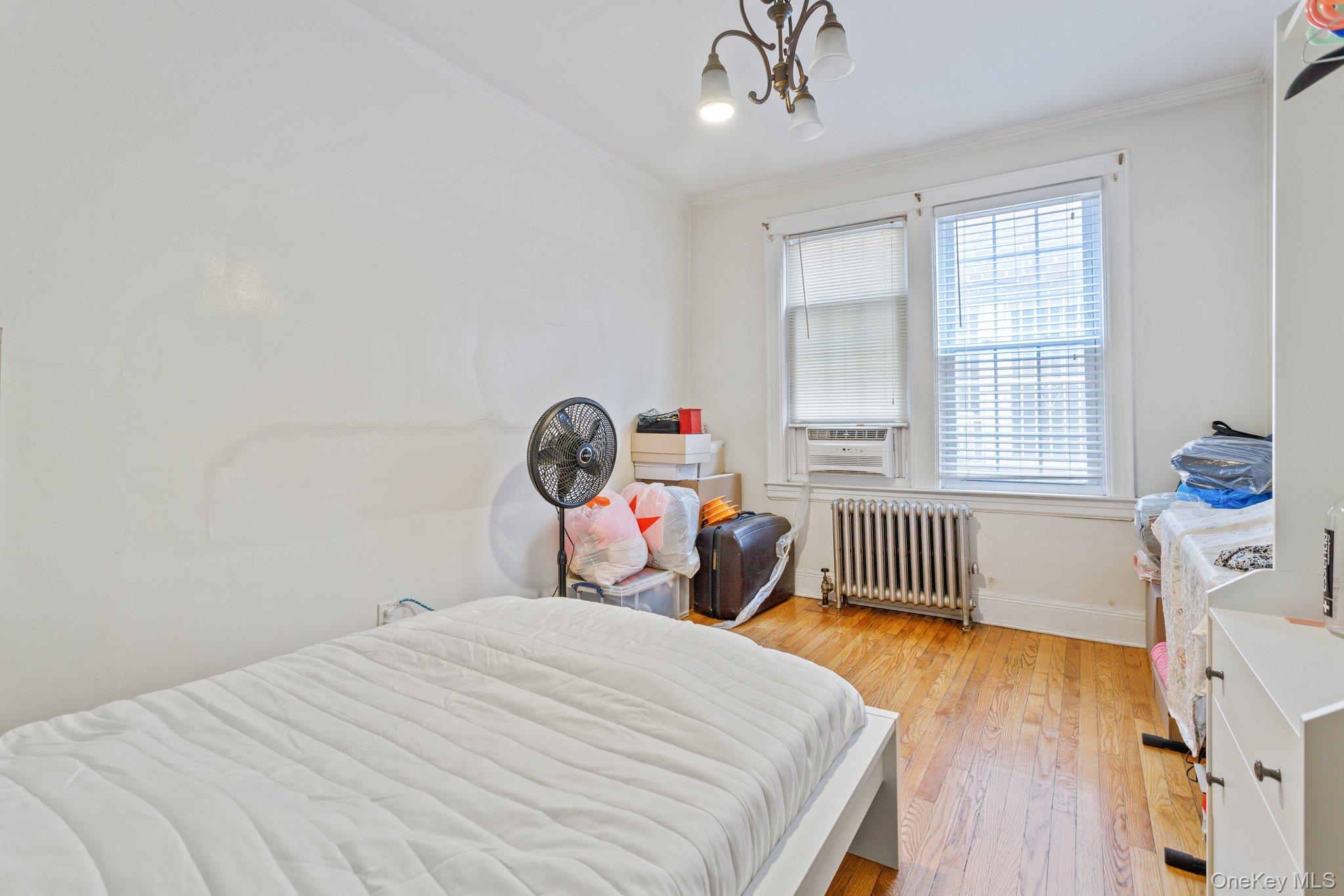 34-29 58th Street Queens, NY 11377 - Photo 9 of 23 a bedroom with a bed and a window