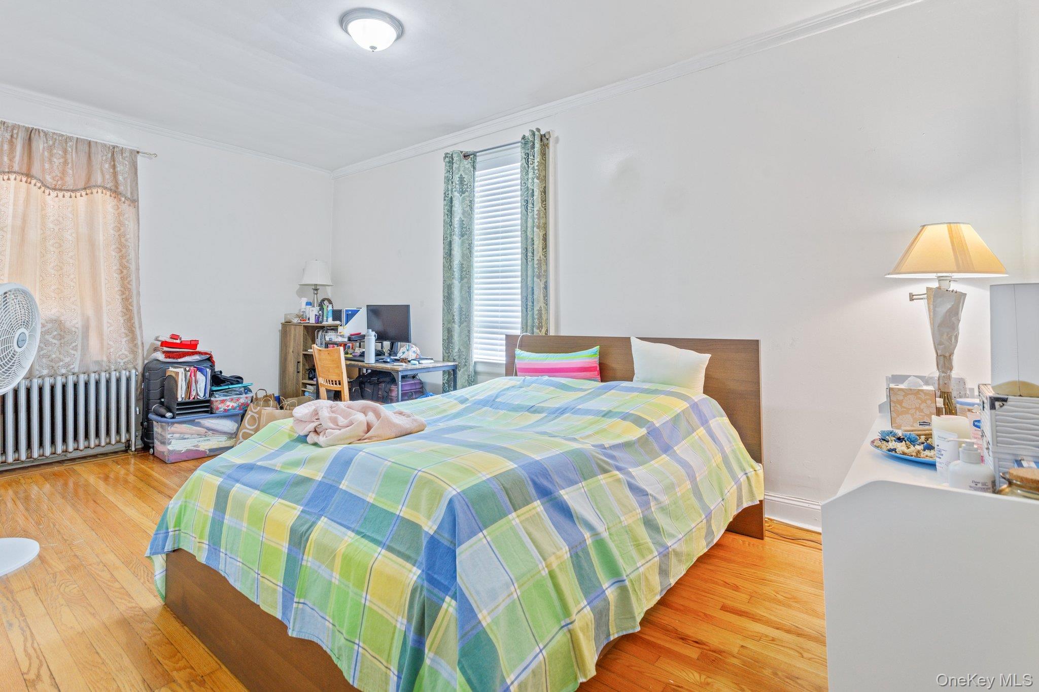 34-29 58th Street Queens, NY 11377 - Photo 10 of 23 a bedroom with a bed and a table in it