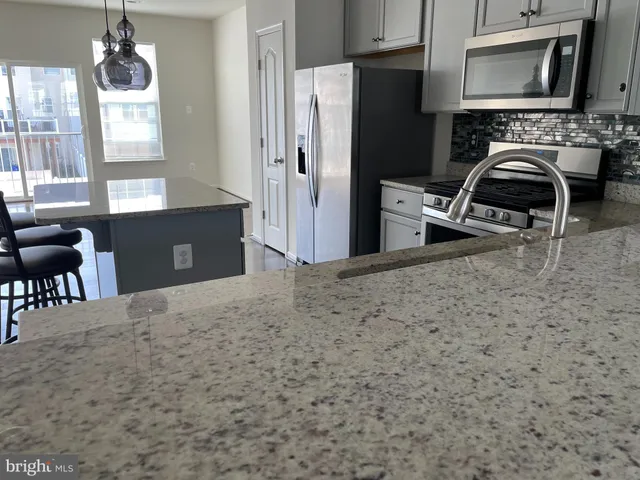 a kitchen with a refrigerator and a stove top oven