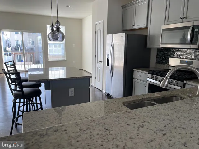 a kitchen with stainless steel appliances granite countertop a stove refrigerator and a microwave