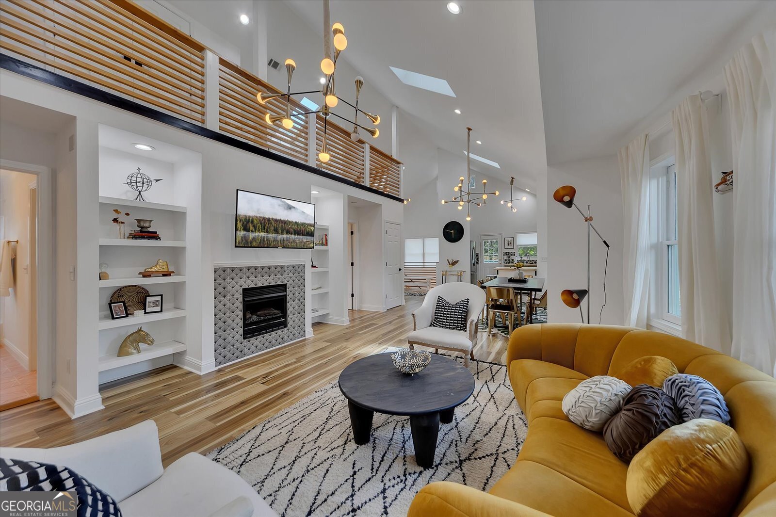 a living room with furniture a fireplace and a chandelier