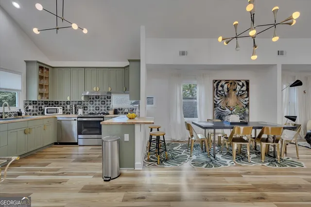 a kitchen with kitchen island granite countertop a sink cabinets and stainless steel appliances