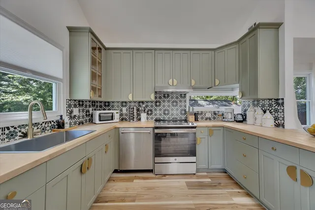 a kitchen with stainless steel appliances granite countertop a refrigerator and a sink