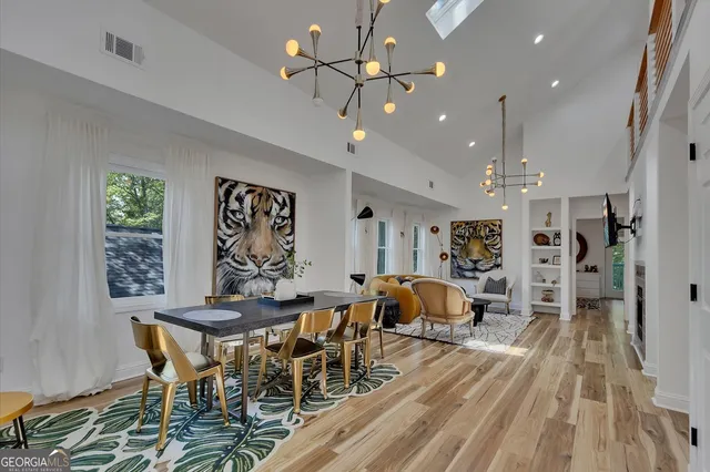 a kitchen with stainless steel appliances a stove a table a chairs and cabinets