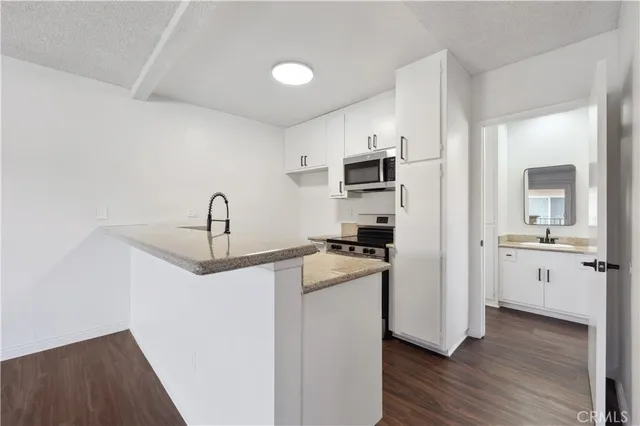 a kitchen with a sink a stove and cabinets