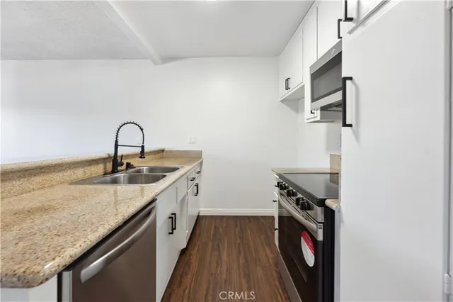 a hallway with granite countertop a sink and a stove top oven
