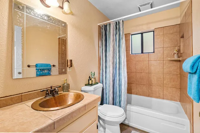 a kitchen with granite countertop a refrigerator stove top oven and sink