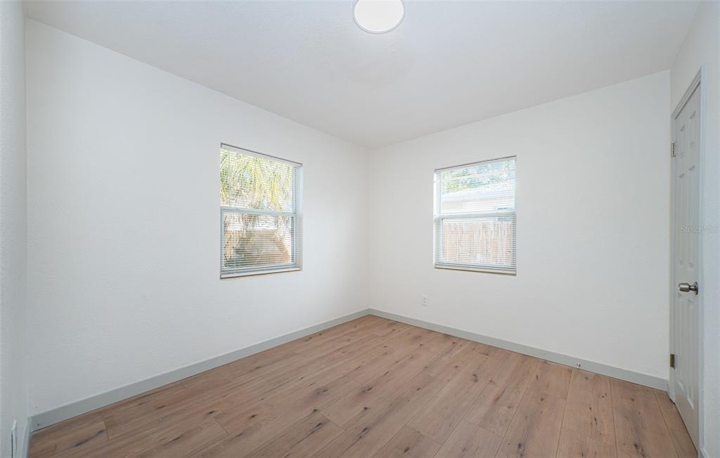 6027 Illinois Avenue New Port Richey, FL 34653 - Photo 11 of 30 an empty room with wooden floor and windows