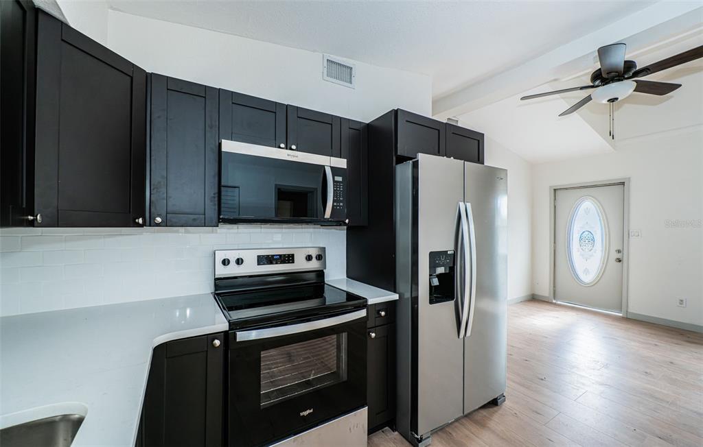 6027 Illinois Avenue New Port Richey, FL 34653 - Photo 15 of 30 a kitchen with stainless steel appliances a refrigerator a stove and cabinets