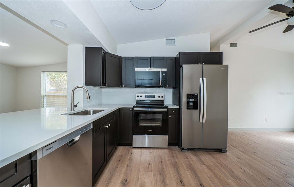 6027 Illinois Avenue New Port Richey, FL 34653 - Photo 16 of 30 a kitchen with granite countertop a refrigerator and a sink