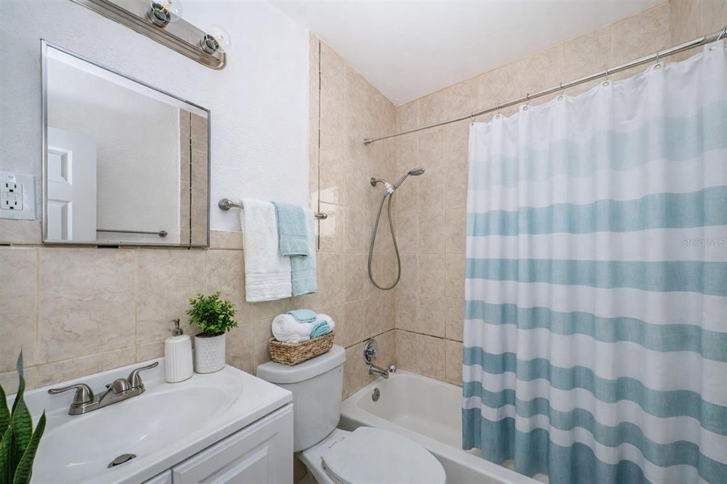 6027 Illinois Avenue New Port Richey, FL 34653 - Photo 20 of 30 a white toilet sitting next to a bathroom sink and a shower