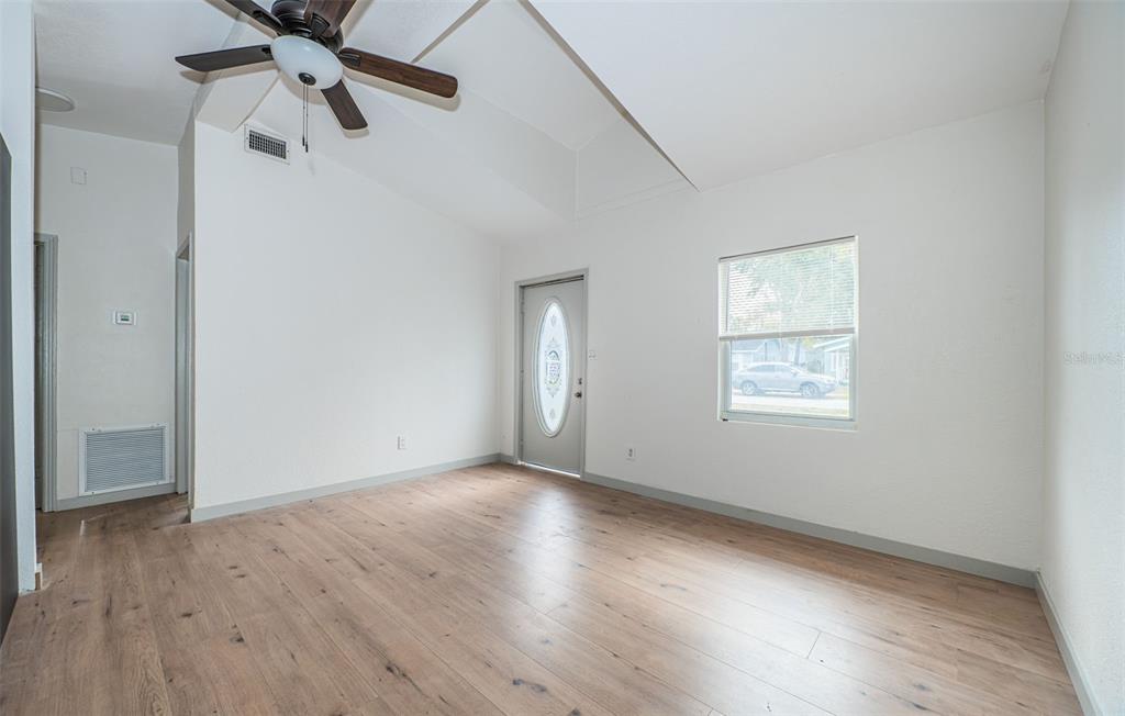 6027 Illinois Avenue New Port Richey, FL 34653 - Photo 3 of 30 a view of an empty room with a window and wooden floor