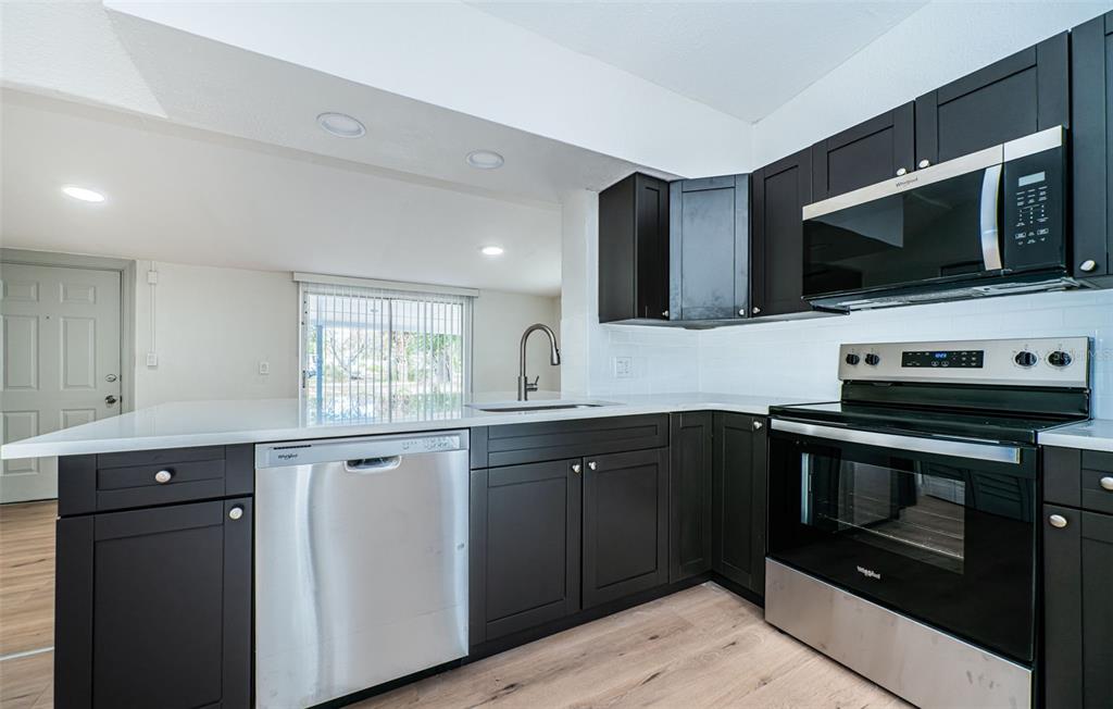 6027 Illinois Avenue New Port Richey, FL 34653 - Photo 4 of 30 a kitchen with a sink and steel stove