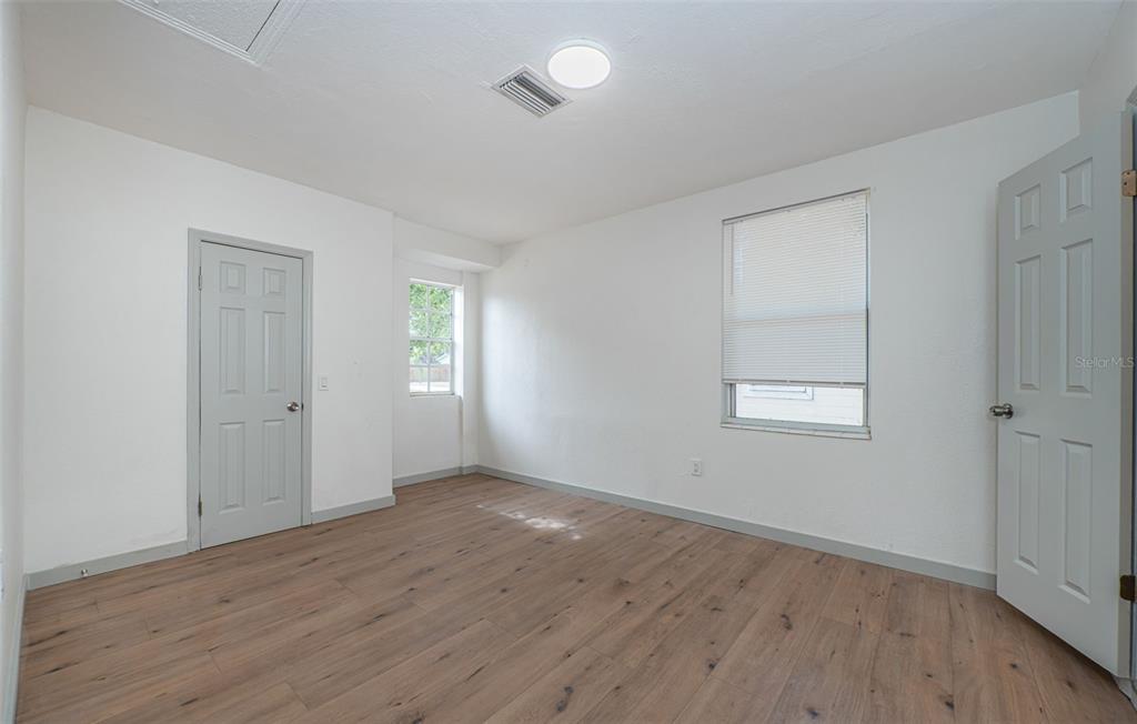 6027 Illinois Avenue New Port Richey, FL 34653 - Photo 7 of 30 an empty room with wooden floor and windows
