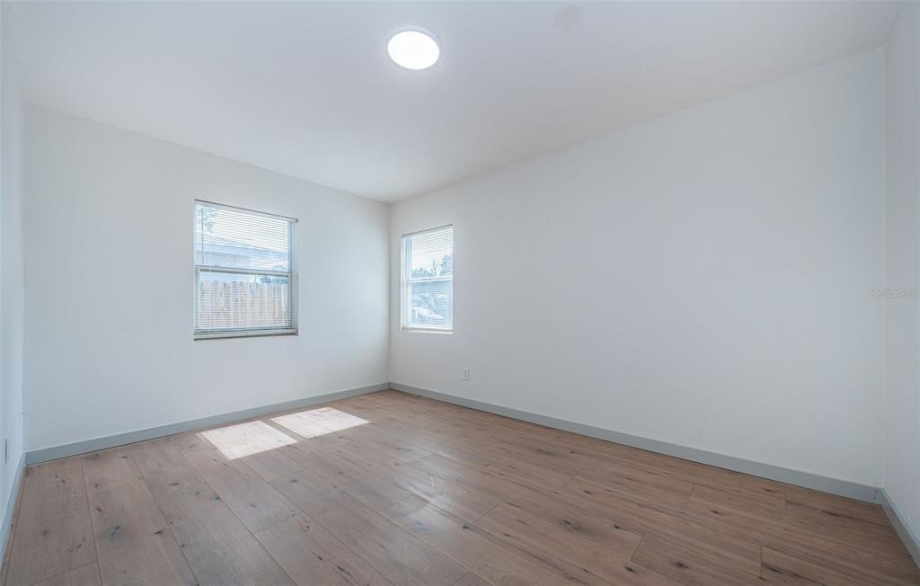 6027 Illinois Avenue New Port Richey, FL 34653 - Photo 9 of 30 an empty room with wooden floor and windows