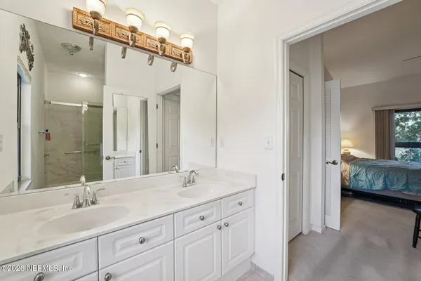 a bathroom with a double vanity sink mirror and window