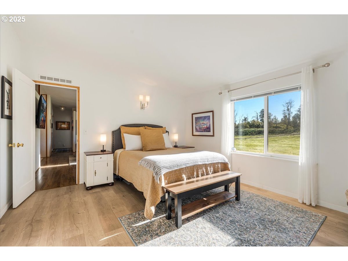 78527 Point Adams Road Clatskanie, OR 97016 - Photo 19 of 46 a spacious bedroom with a bed and wooden floor