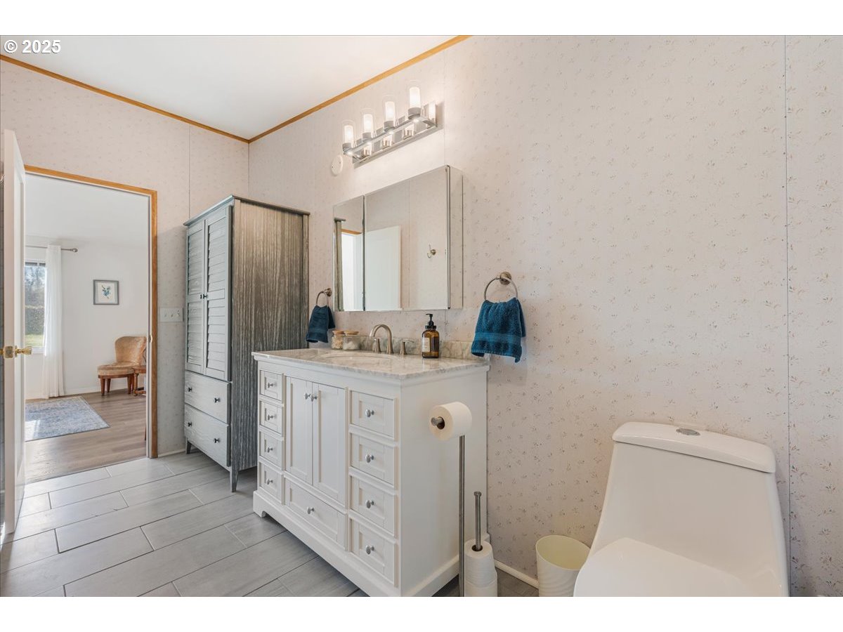 78527 Point Adams Road Clatskanie, OR 97016 - Photo 21 of 46 a en suite bathroom with a granite countertop sink and a mirror