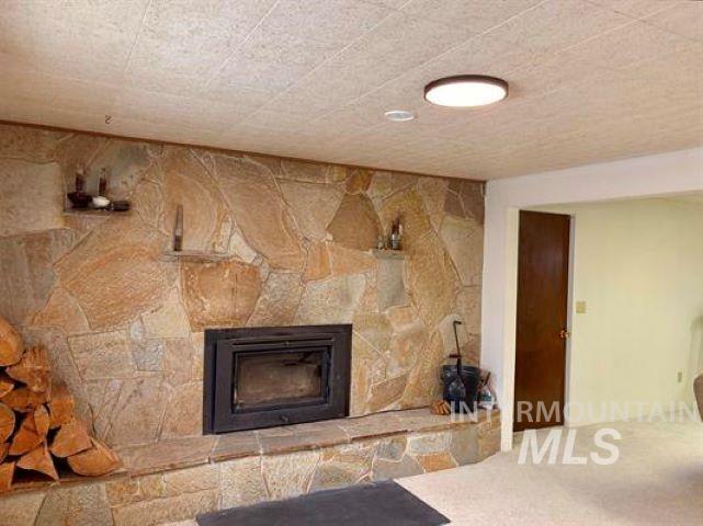 3197 Neeley Road American Falls, ID 83211 - Photo 25 of 45 Stone veneer fireplace featuring a built-in wood-burning insert and stone hearth