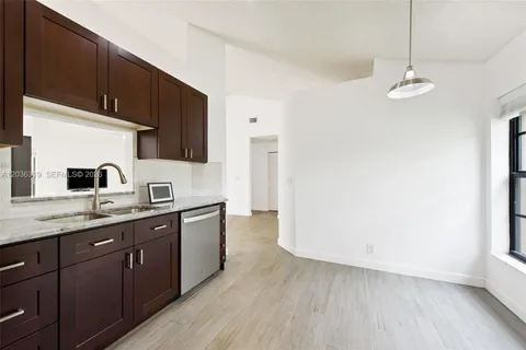 a kitchen with granite countertop a sink stainless steel appliances and cabinets