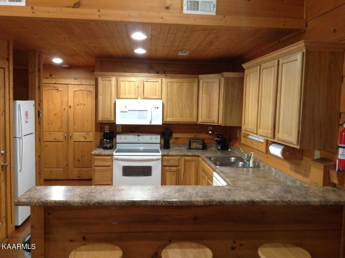 315 Windrock Road Oliver Springs, TN 37840 - Photo 12 of 36 a kitchen with kitchen island granite countertop a sink cabinets and stainless steel appliances