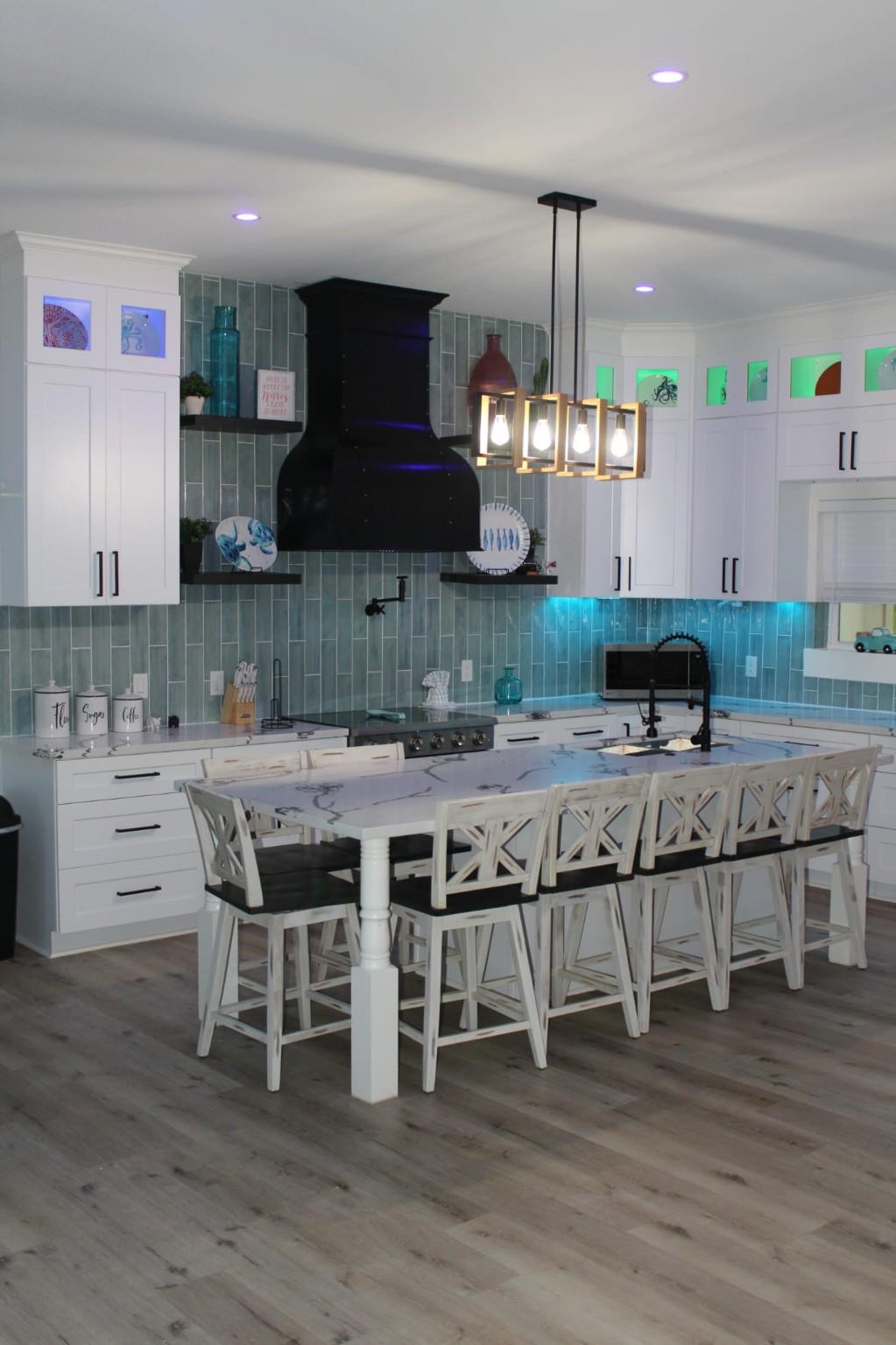 23245 Termini-San Luis Pass Road Galveston, TX 77554 - Photo 25 of 45 a kitchen with stainless steel appliances granite countertop a stove a sink dishwasher a dining table and chairs with wooden floor