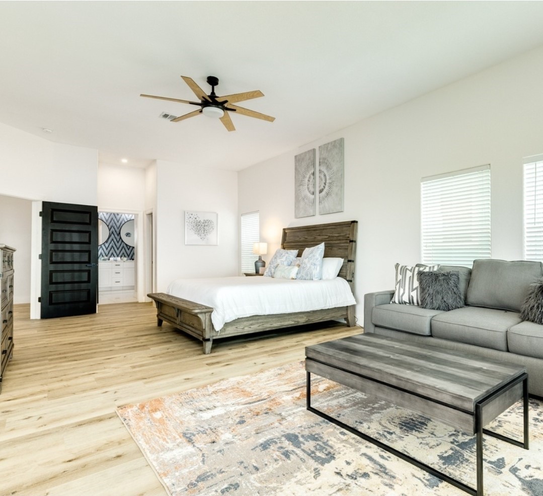 23245 Termini-San Luis Pass Road Galveston, TX 77554 - Photo 28 of 45 a spacious bedroom with a bed a couch and a ceiling fan