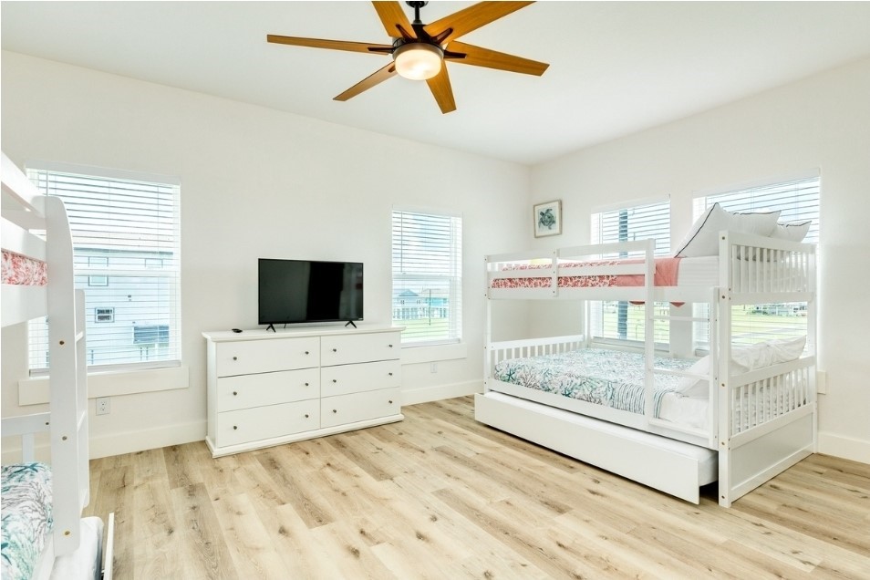 23245 Termini-San Luis Pass Road Galveston, TX 77554 - Photo 36 of 45 a room with a bed and a flat screen tv in a dresser