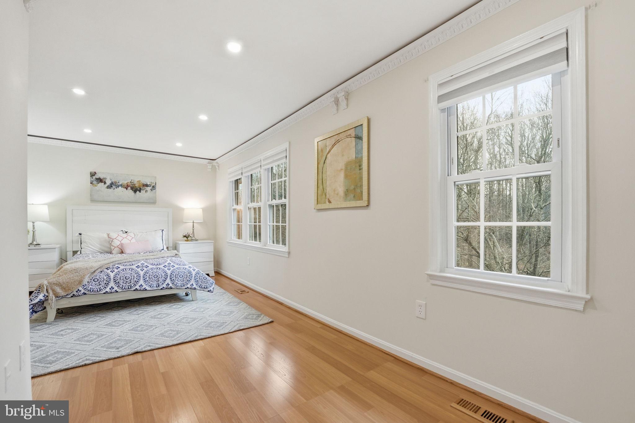 8967 Omega Court Springfield, VA 22152 - Photo 14 of 31 a bedroom with a bed and wooden floor