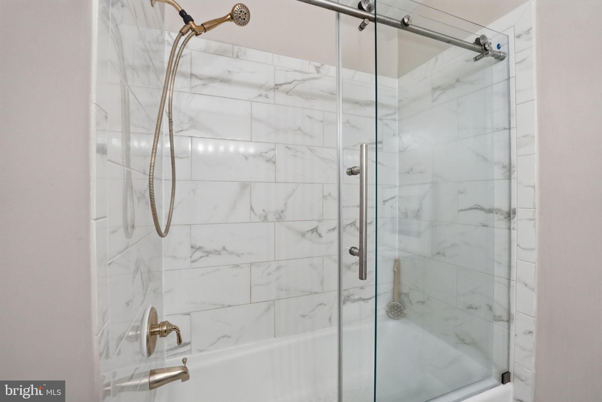 8967 Omega Court Springfield, VA 22152 - Photo 17 of 31 a bathroom with a glass shower door
