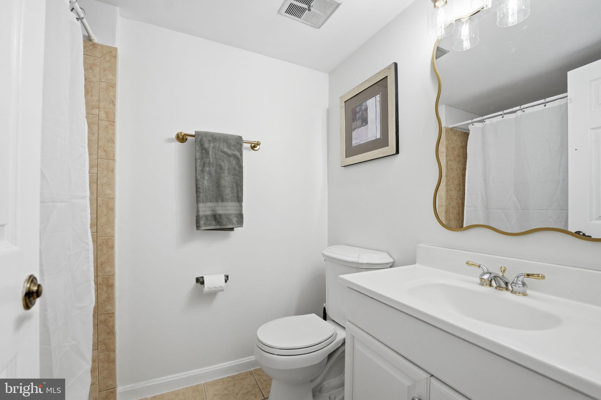 8967 Omega Court Springfield, VA 22152 - Photo 23 of 31 a bathroom with a toilet sink and mirror