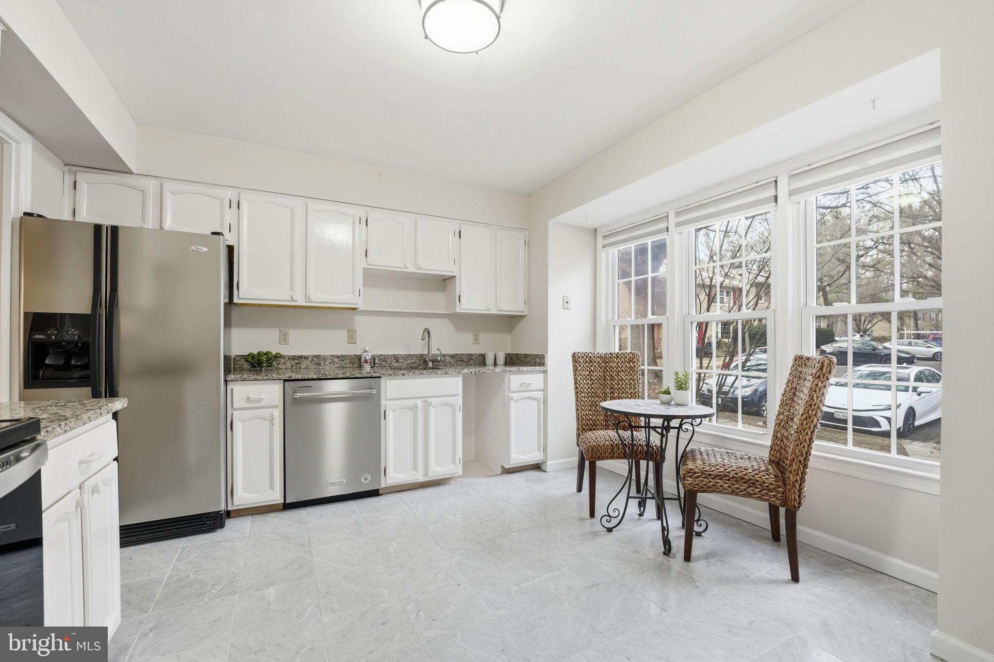8967 Omega Court Springfield, VA 22152 - Photo 8 of 31 a kitchen with refrigerator and chairs