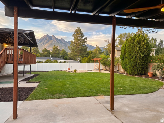 1860 Spring Lane Holladay, UT 84117 - Photo 28 of 32 Expansive concrete patio with a covered outdoor area, overlooking a spacious lawn