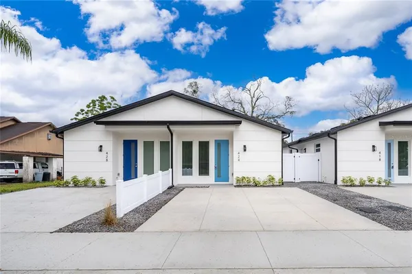 a front view of a house with a yard and potted plants