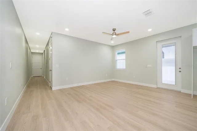 an empty room with a window and a ceiling fan