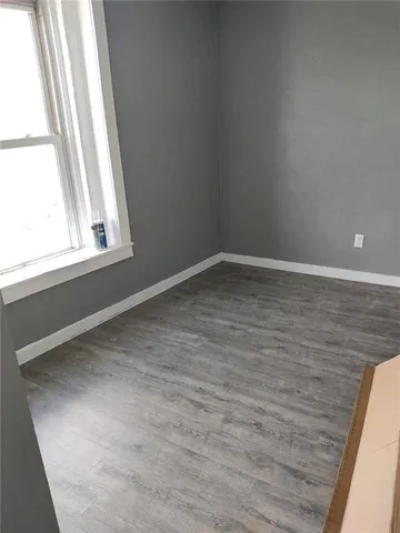 a living room with stainless steel appliances wooden floors and view kitchen