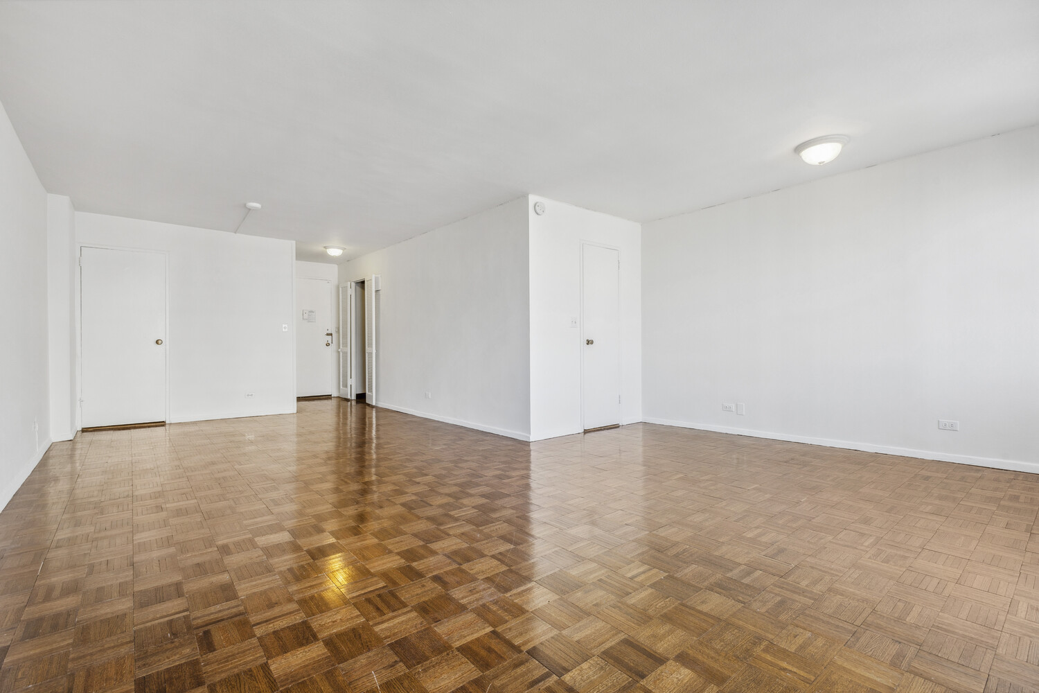 155 West 68th Street, Unit 1807 Manhattan, NY 10023 - Photo 2 of 7 a view of an empty room with wooden floor