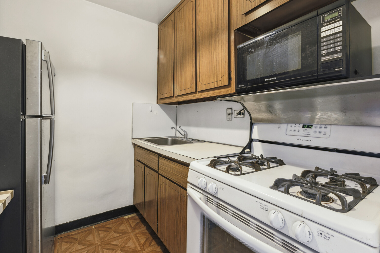 155 West 68th Street, Unit 1807 Manhattan, NY 10023 - Photo 5 of 7 a kitchen with stainless steel appliances granite countertop a sink stove and refrigerator