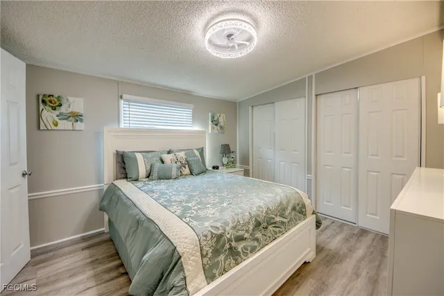a bedroom with a bed and a lamp on dresser