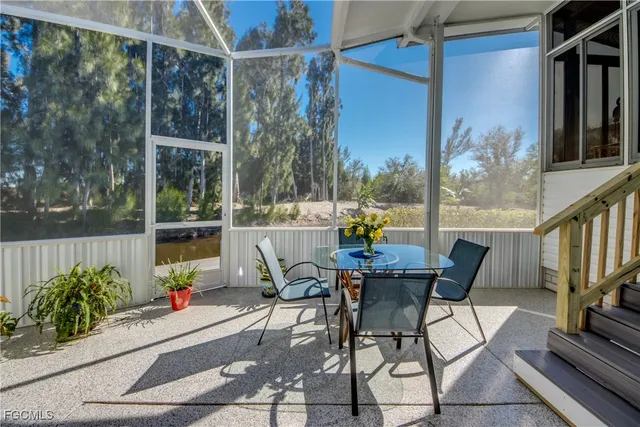a view of swimming pool with seating space and trees in the background