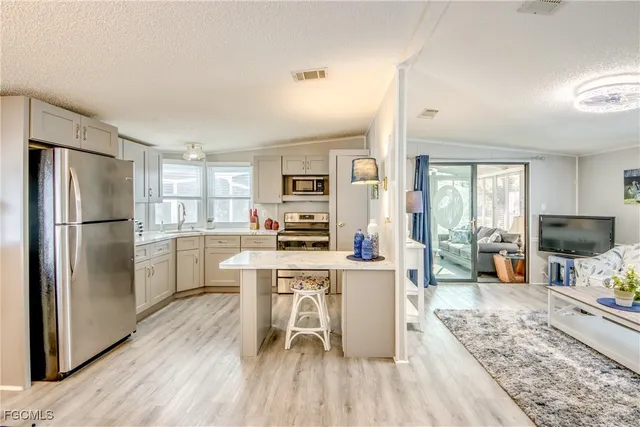 a kitchen with stainless steel appliances a refrigerator sink and cabinets