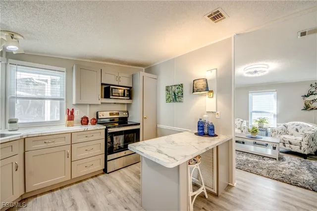 a kitchen with stainless steel appliances granite countertop a refrigerator sink and stove