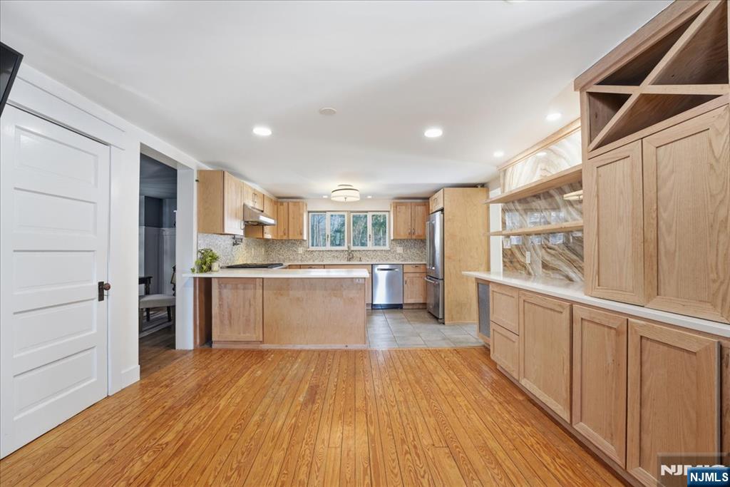 343-339 Quaker Church Road Randolph, NJ 07869 - Photo 23 of 38 a kitchen with stainless steel appliances wooden floors and white cabinets