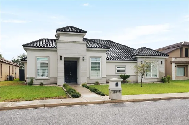 a front view of a house with a garden and plants