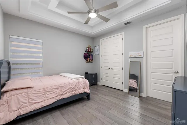 a bedroom with a bed closet and wooden floor