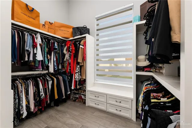 a view of walk in closet with clothes and shoes
