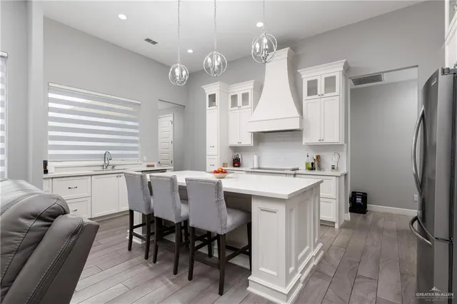a kitchen with a table chairs refrigerator and cabinets