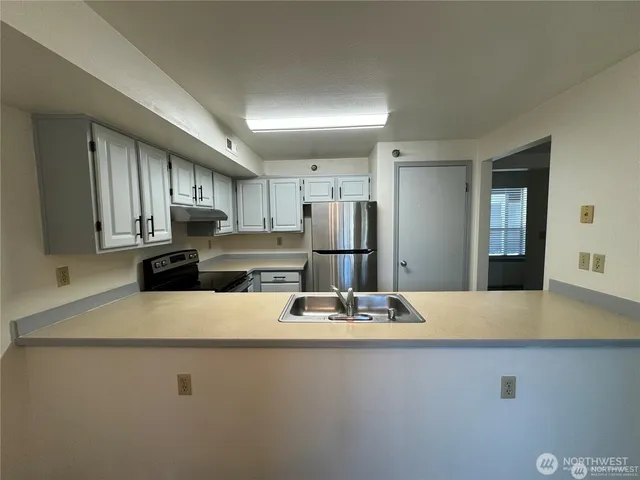 a kitchen with stainless steel appliances a refrigerator sink and cabinets