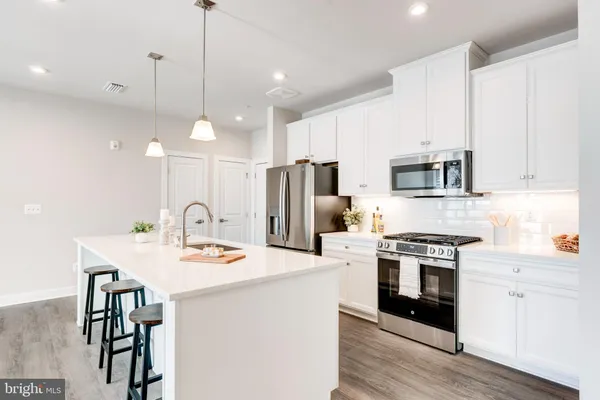 a kitchen with a sink cabinets and wooden floor